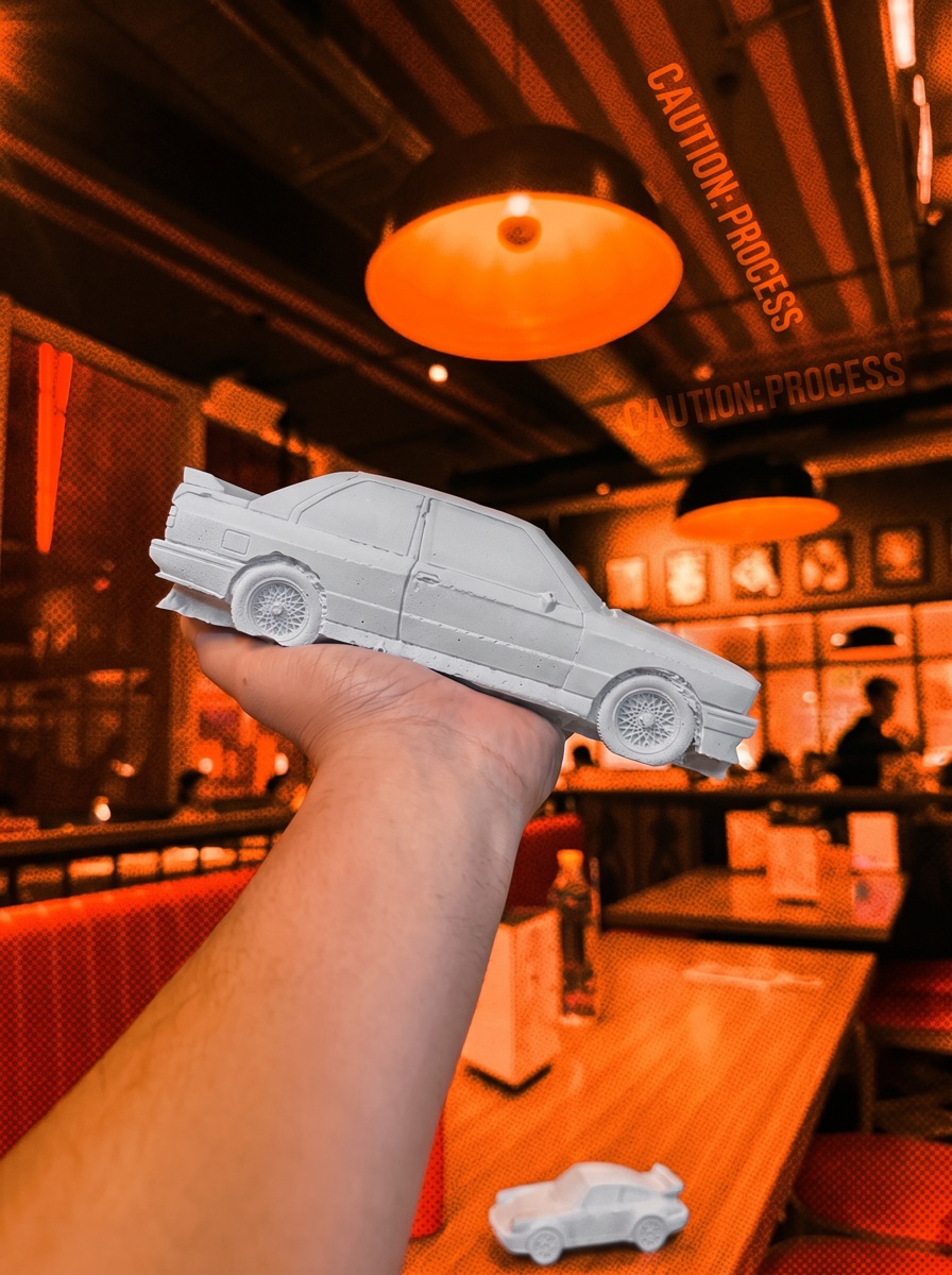A hand holding the grey concrete saloon in a warm-lit café