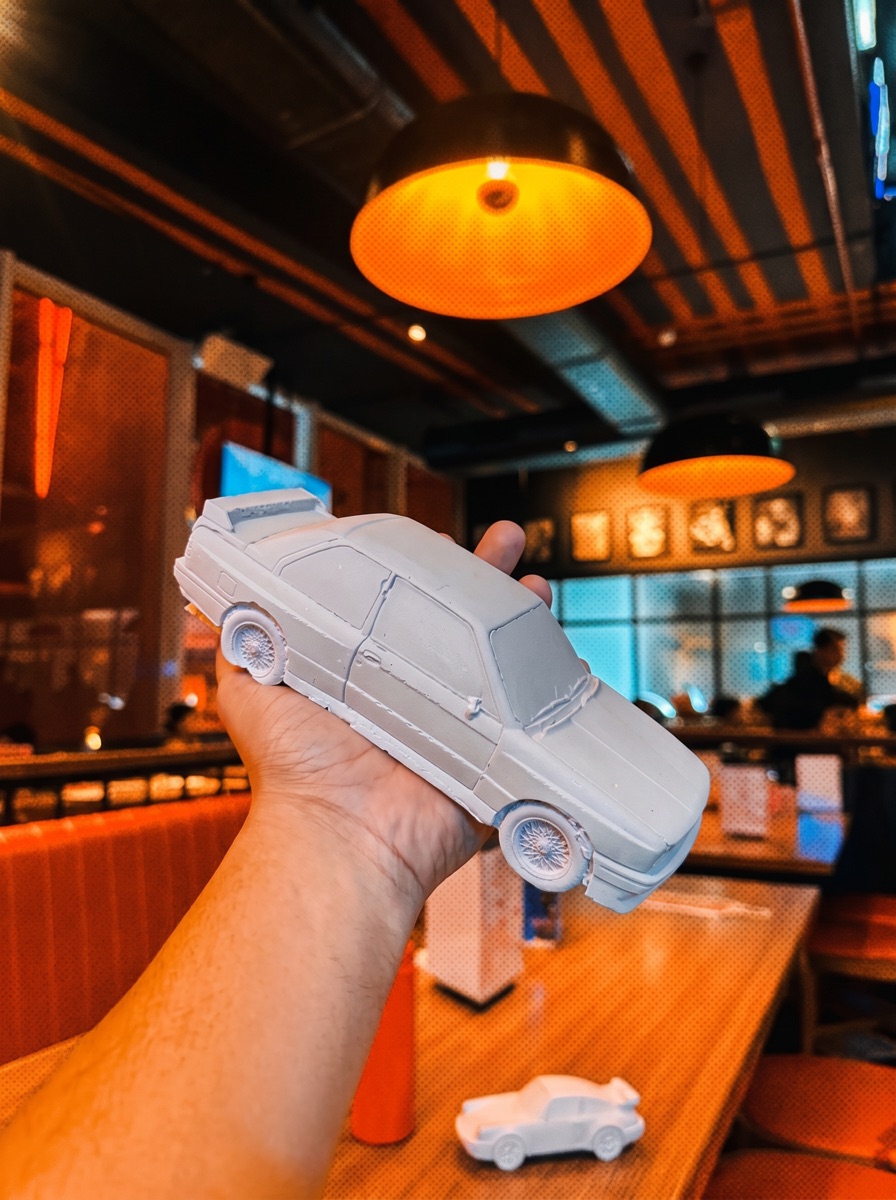 A hand holding the concrete saloon, café interior behind