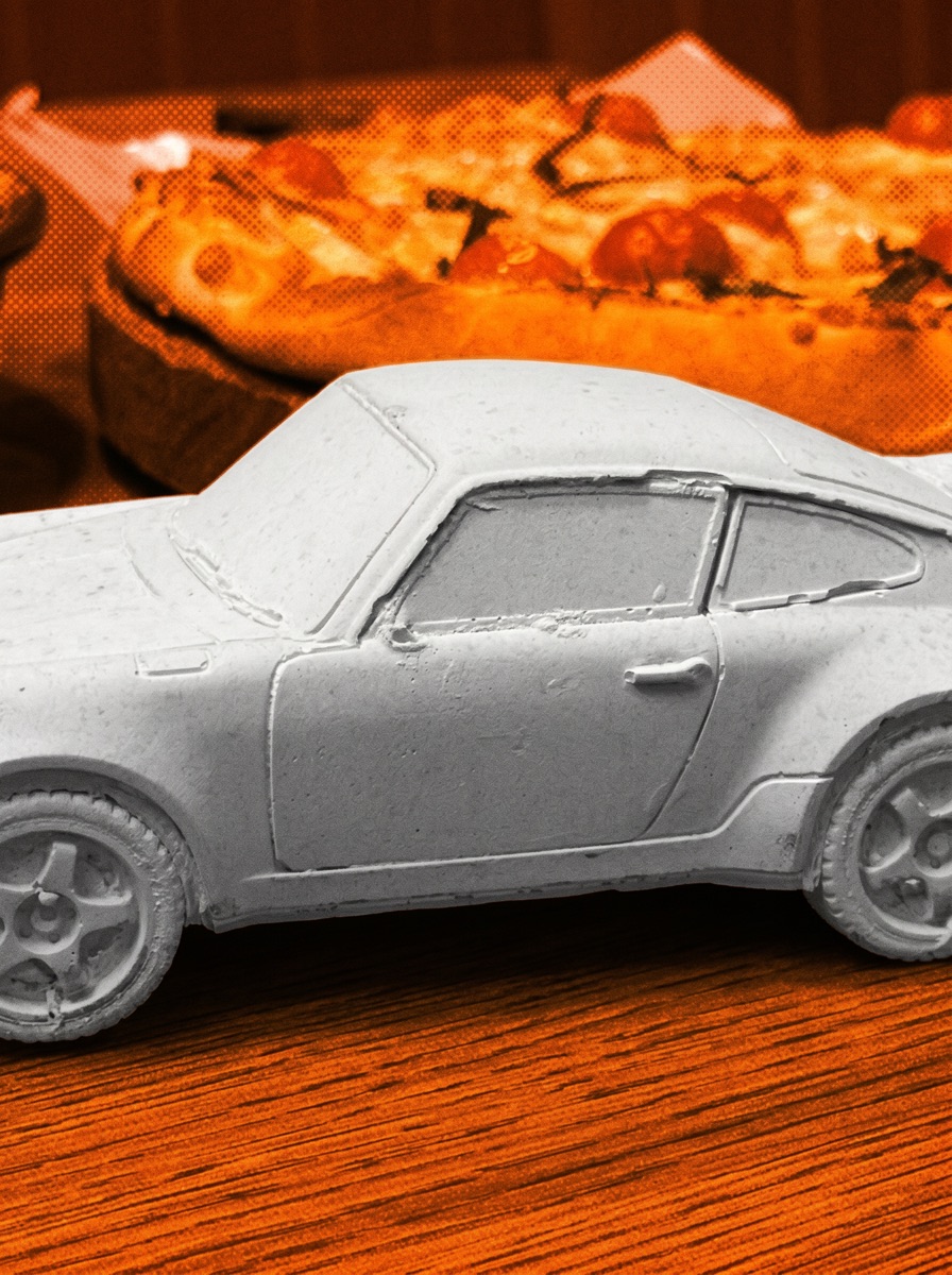 The grey concrete coupe with a pizza behind it