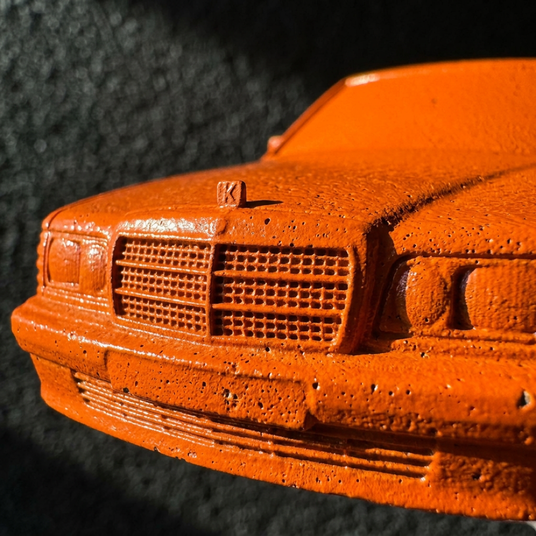 Macro detail of the hazard-orange grille and concrete texture