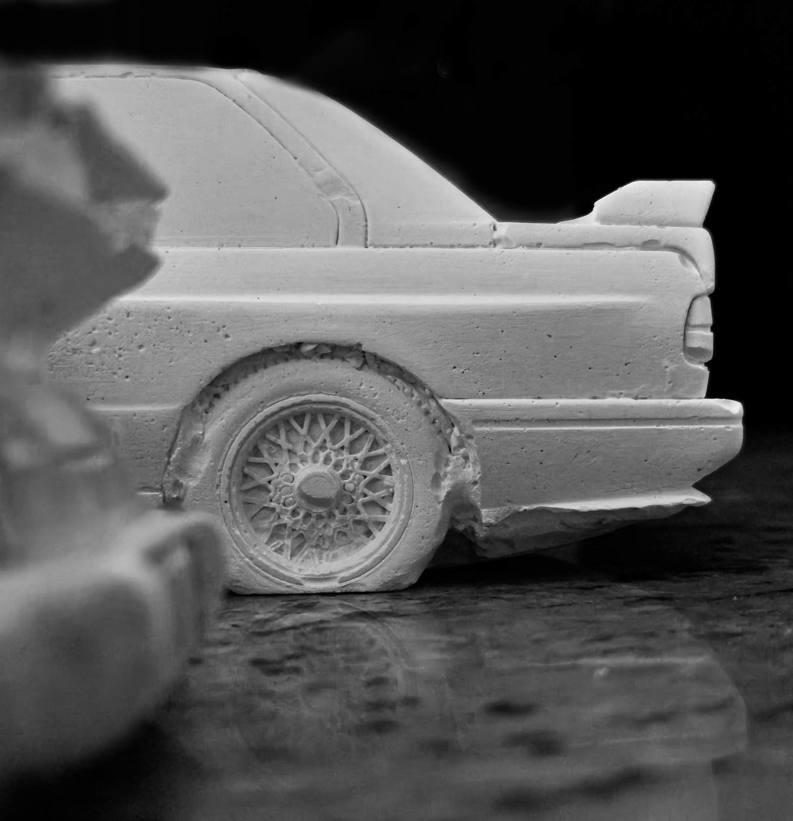 Close detail of the saloon's cast rear wing and mesh wheel, low light